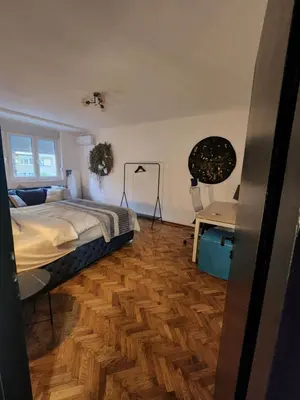 a bedroom with a bed and a desk at Nancy's Cozy Business Apartment in Bežanija