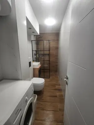 a white bathroom with a toilet and a sink at Nancy's Cozy Business Apartment in Bežanija