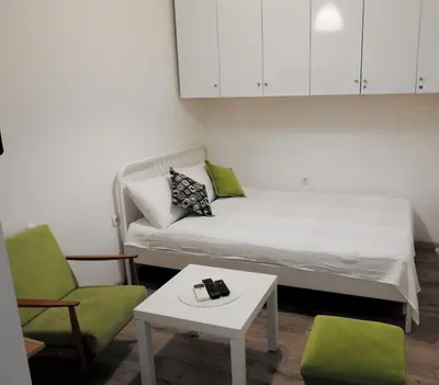 a small room with a bed and two chairs and a table at Vukov spomenik in Belgrade
