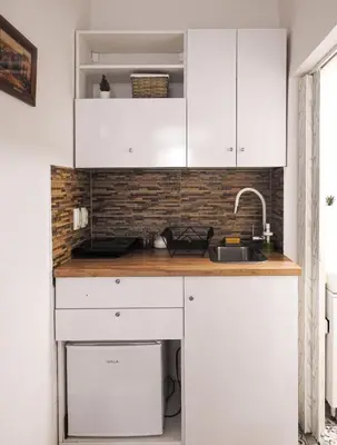 a kitchen with white cabinets and a sink at Vukov spomenik in Belgrade