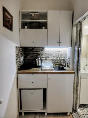 a small kitchen with white cabinets and a sink at Vukov spomenik in Belgrade