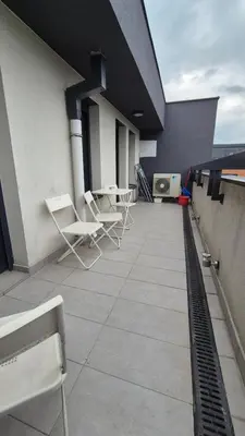 a balcony with chairs and tables on a building at Skyline in Belgrade