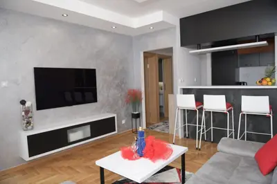 a living room with a couch and a tv on a wall at Arena Lux in Novi Beograd