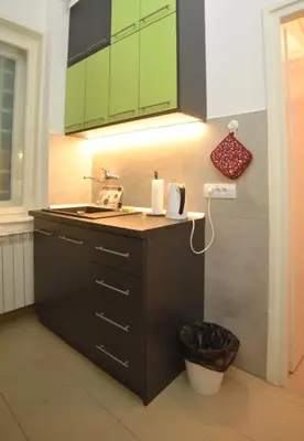 a kitchen with green cabinets and a sink at Cloud Downtown apartment in Belgrade
