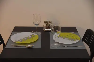 a black table with two plates and wine glasses at Cloud Downtown apartment in Belgrade