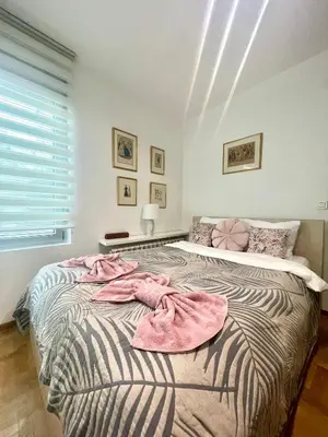 a bedroom with a bed with pink towels on it at Regina Vracar apartment and garage in Vračar (historical)