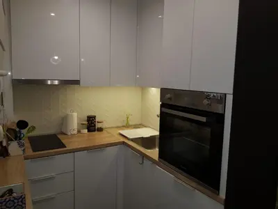 a kitchen with white cabinets and a black oven at Emily apartment in Belgrade