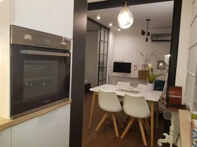 a kitchen and dining room with a white table and chairs at Emily apartment in Belgrade