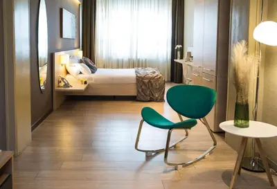 a bedroom with a bed and a chair and a table at Prince Hall in Belgrade