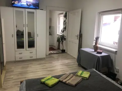 a room with two beds and a table and a television at Central apartment Belgrade in Belgrade