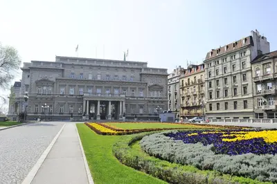 a large building with flowers in front of it at Central apartment Belgrade in Belgrade
