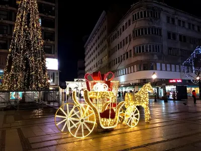 a horse drawn carriage decorated with lights in front of a christmas tree at Central apartment Belgrade in Belgrade