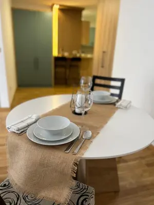 a wooden table with plates and utensils on it at Lenka in Dušanovac (historical)