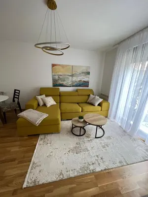 a living room with a yellow couch and a table at Lenka in Dušanovac (historical)