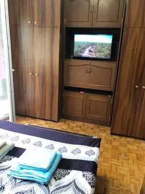 a bedroom with a bed and a tv in a cabinet at Champion in Belgrade