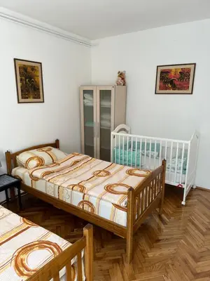 two beds in a room with white walls and wooden floors at Champion in Belgrade