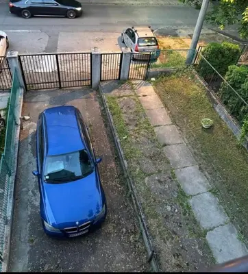 a blue car parked in a parking lot at Champion in Belgrade