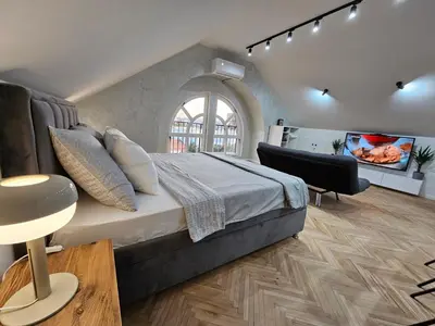 a bedroom with a bed and a flat screen tv at Apartment LUMALU in Belgrade