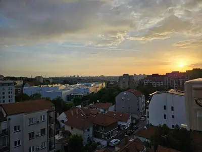 a view of a city with the sunset in the background at Apartment LUMALU in Belgrade