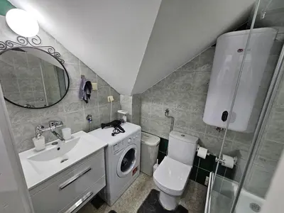 a bathroom with a sink and a washing machine at Apartment LUMALU in Belgrade