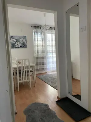 a room with a mirror and a dining room with a table at JOVAN APARTMAN in Rospi Ćuprija