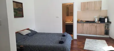 a small bedroom with a bed and a kitchen at The Bridgeview Suite in Belgrade
