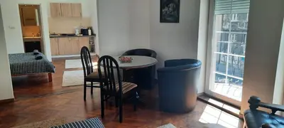 a living room with a table and chairs and a kitchen at The Bridgeview Suite in Belgrade