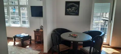 a small table and chairs in a room with a table and windows at The Bridgeview Suite in Belgrade