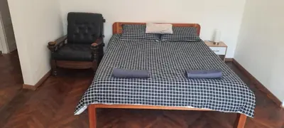 a bed with a black and white checkered blanket and a chair at The Bridgeview Suite in Belgrade