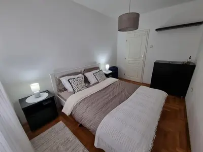 a bedroom with a bed and two lamps on tables at THE FIVE-OLD TOWN Apartments in Belgrade