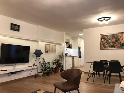 a living room with a television and a table and chairs at Art City Center Apartment in Belgrade