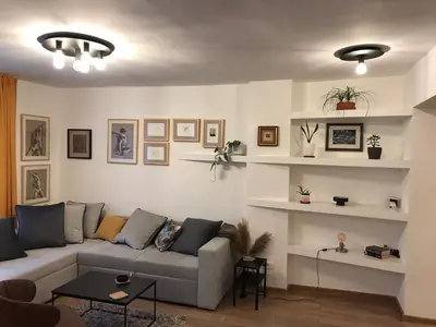 a living room with a couch and shelves at Art City Center Apartment in Belgrade