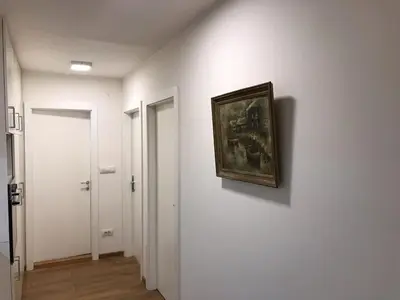 a painting hanging on a wall in a hallway at Art City Center Apartment in Belgrade