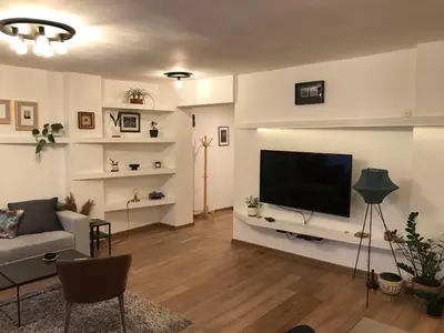 a living room with a couch and a flat screen tv at Art City Center Apartment in Belgrade