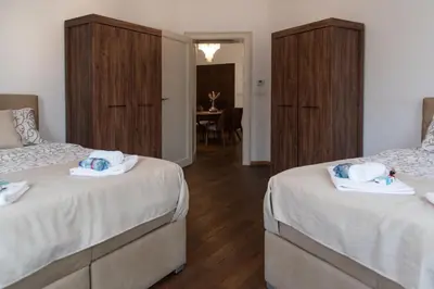 a bedroom with two beds and a dining room at Balkan dream **** in Belgrade