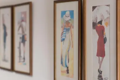 a group of framed pictures of women on a wall at Balkan dream **** in Belgrade