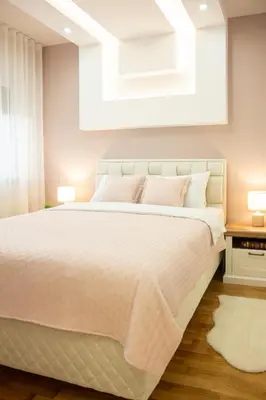 a bedroom with a large white bed with two lamps at Cherry Lux Apartments in Arandjelovac