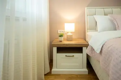 a bedroom with a bed and a table with a lamp at Cherry Lux Apartments in Arandjelovac