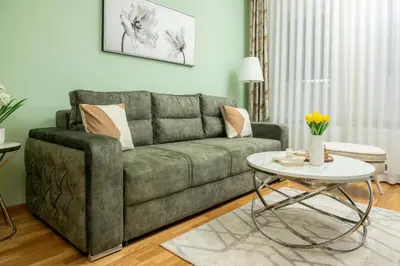 a living room with a green couch and a table at Cherry Lux Apartments in Arandjelovac
