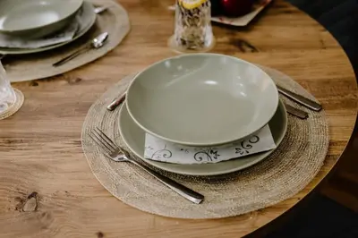 a table with plates and silverware on a wooden table at Cherry Lux Apartments in Arandjelovac