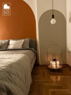 a bedroom with a bed and a table with a lamp at Studio 50 in Belgrade