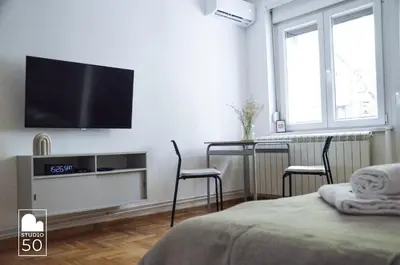 a bedroom with a flat screen tv on a wall at Studio 50 in Belgrade