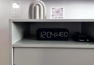 an alarm clock sitting on a shelf next to a sink at Studio 50 in Belgrade