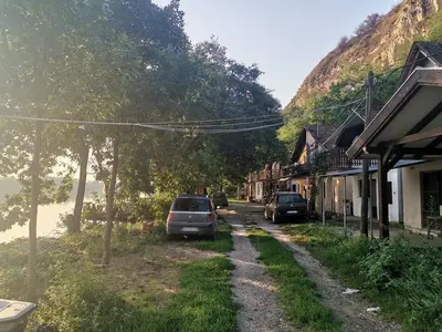 a street with cars parked on the side of a mountain at Vikendica Tisa Dukatar in Titel