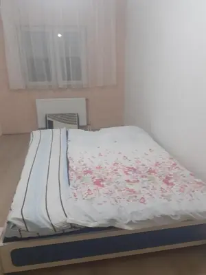 a bed with a white blanket with flowers on it at Dunav in Smederevo