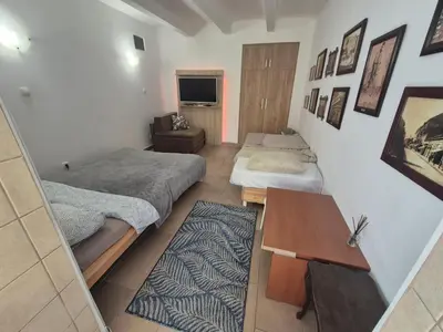 a small room with two beds and a table at Booking Apartments Alone 1 in Belgrade