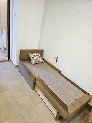 a bed in the corner of a room at Booking Apartments Alone 2 in Zemun