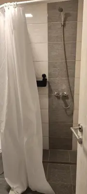a shower with a white shower curtain in a bathroom at Miljakovački konak in Belgrade