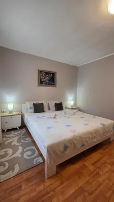 a large bed in a bedroom with two night stands at Apart Zen House in Borča