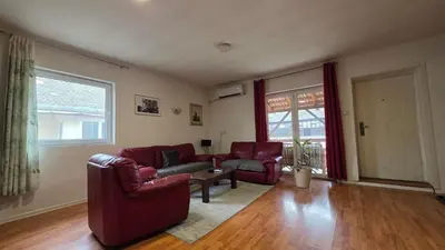 a living room with two couches and a table at Apart Zen House in Borča